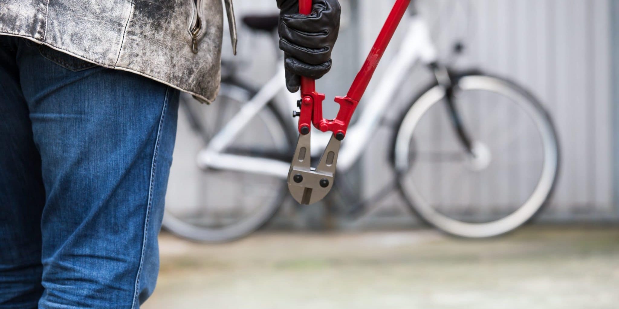 Person läuft mit Zange auf angeschlossenes Fahrrad zu
