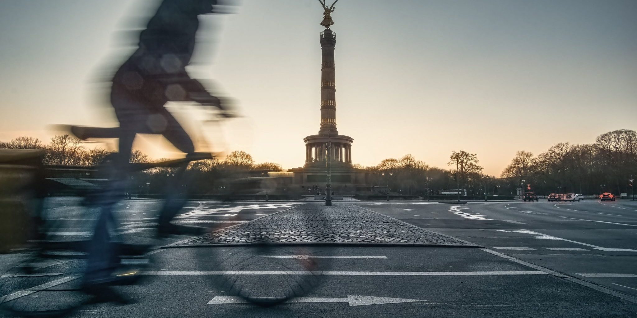 Radfahrer fährt in Berlin an der Siegessäule schnell über eine Straße